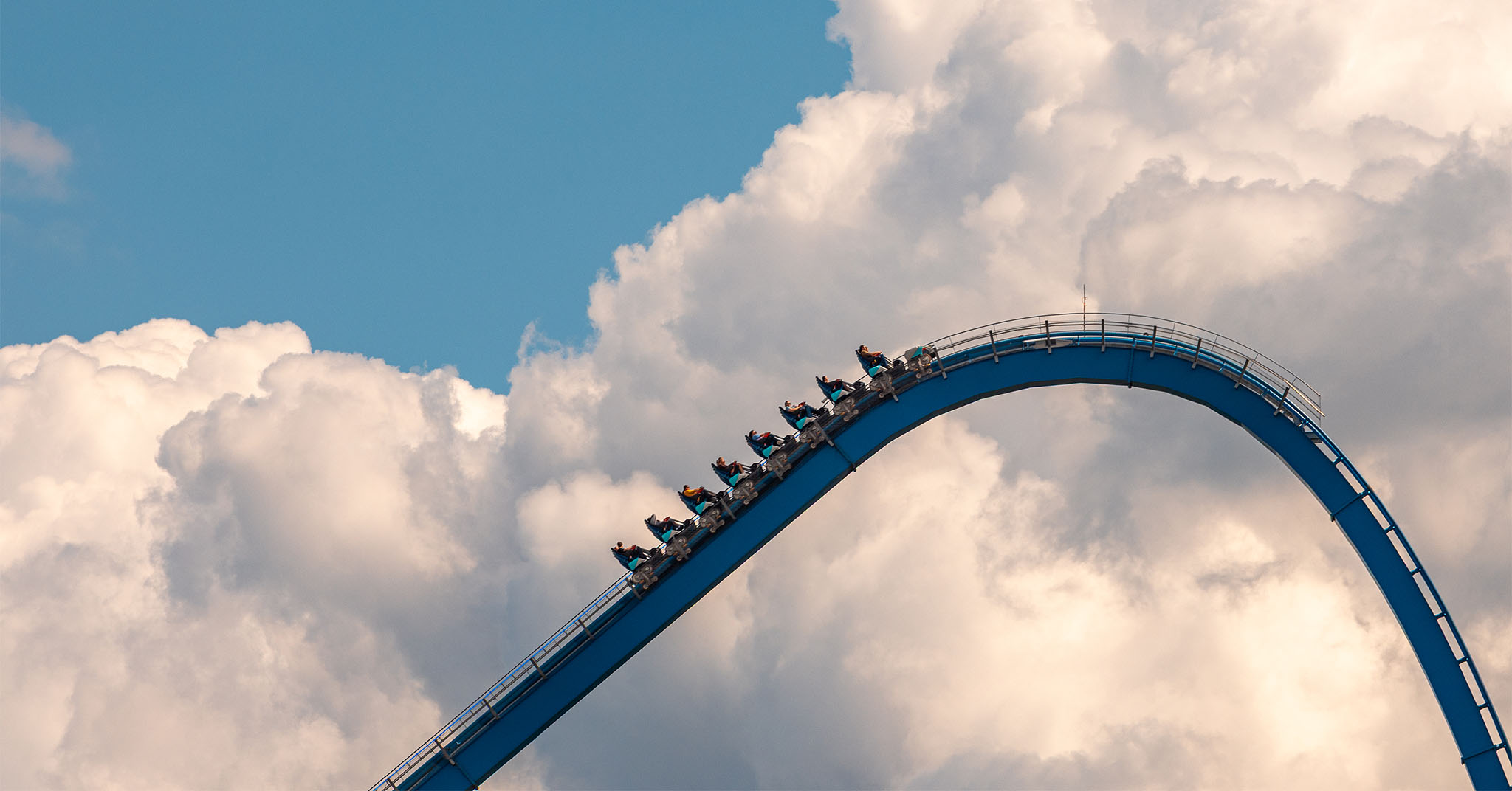 The top of Orion's 287-foot lift hill, with huge puffy clouds behind it.